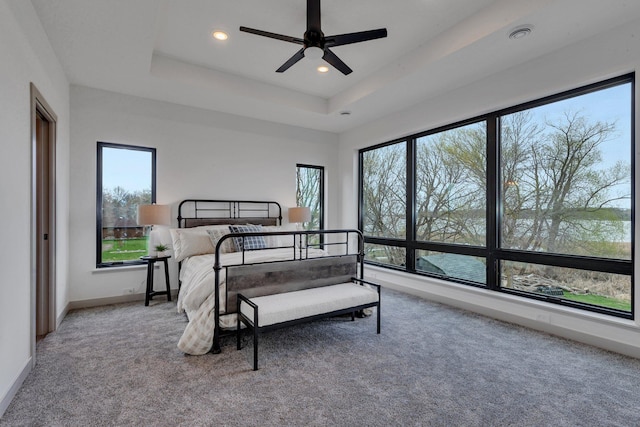 carpeted bedroom with recessed lighting, a raised ceiling, baseboards, and a ceiling fan