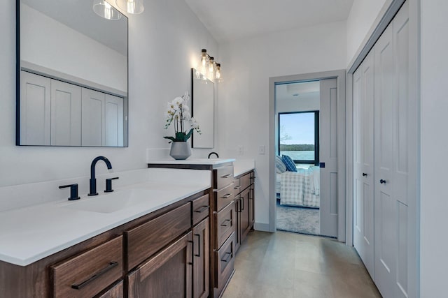 full bathroom with a closet, vanity, and ensuite bath