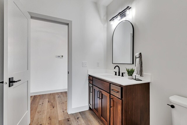 21070 Eagle Dr, Osakis, MN 56360 - bathroom with vanity, wood finished floors, toilet, and baseboards