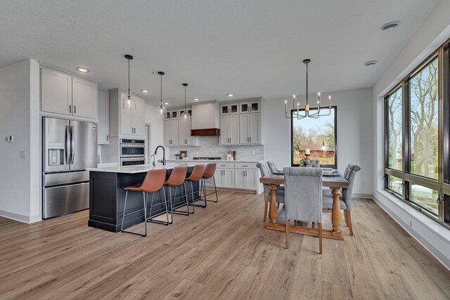 21070 Eagle Dr, Osakis, MN 56360 - dining area with a chandelier, light wood finished floors, baseboards, and recessed lighting