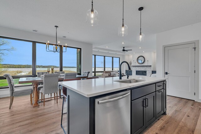21070 Eagle Dr, Osakis, MN 56360 - kitchen with dishwasher, a sink, light wood-style flooring, light countertops, and open floor plan