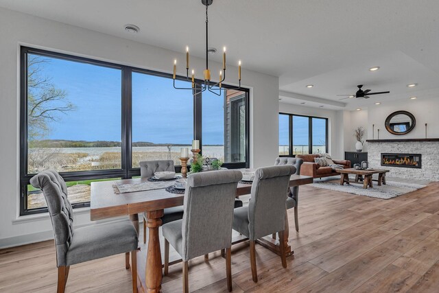 21070 Eagle Dr, Osakis, MN 56360 - dining space featuring wood finished floors, a water view, a fireplace, recessed lighting, and a chandelier