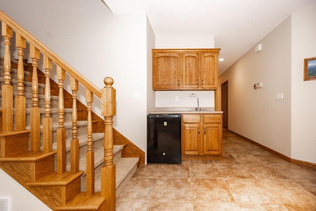 15671 Wermager Beach Rd, Lake Park, MN 56554 - kitchen featuring black dishwasher, light countertops, baseboards, a sink, and brown cabinets