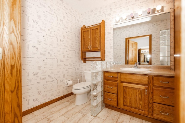 15671 Wermager Beach Rd, Lake Park, MN 56554 - bathroom featuring wallpapered walls, vanity, toilet, wood finished floors, and baseboards