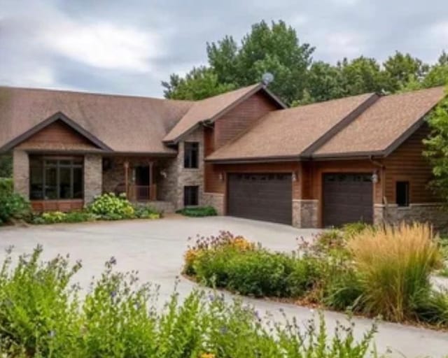 15671 Wermager Beach Rd, Lake Park, MN 56554 - view of front of home with stone siding, a garage, and concrete driveway