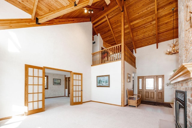 15671 Wermager Beach Rd, Lake Park, MN 56554 - unfurnished living room featuring wood ceiling with exposed beams, french doors, a brick fireplace, high vaulted ceiling, and carpet flooring