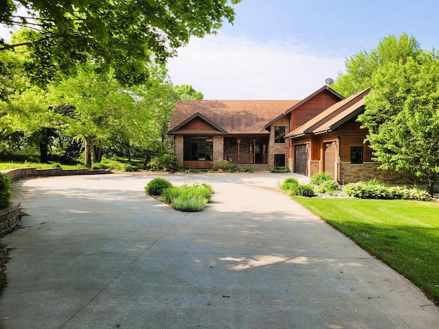 15671 Wermager Beach Rd, Lake Park, MN 56554 - view of front facade featuring concrete driveway, brick siding, an attached garage, and a front lawn