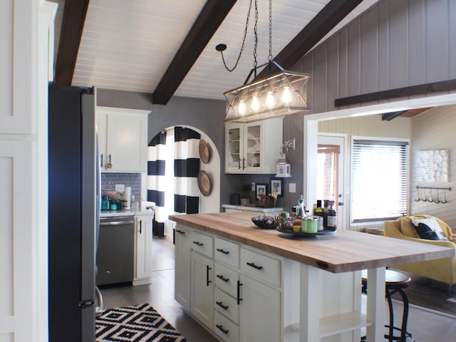 22010 62nd St NW, Colfax Twp, MN 56289 - kitchen with white cabinets, lofted ceiling with beams, wooden counters, stainless steel appliances, and decorative backsplash