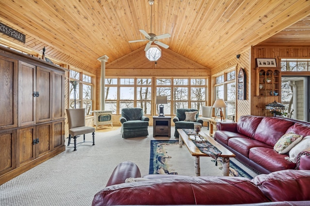 32331 Loon Dr, Candor Twp, MN 56587 - carpeted living area featuring a wood stove, vaulted ceiling, wood ceiling, a ceiling fan, and wooden walls