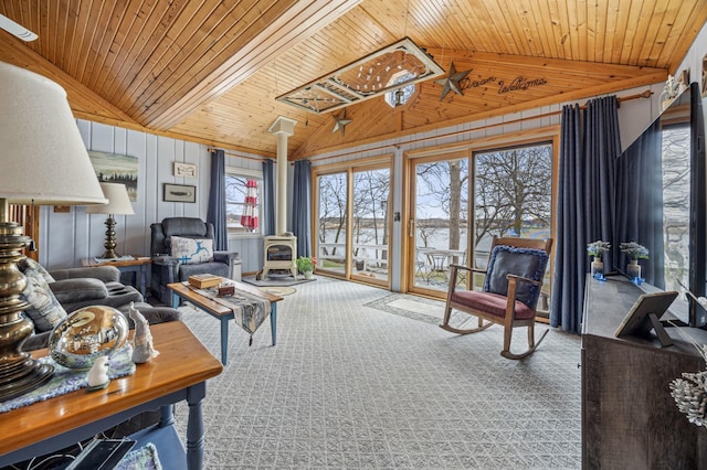 32331 Loon Dr, Candor Twp, MN 56587 - living area featuring a wood stove, vaulted ceiling, wood ceiling, and carpet flooring