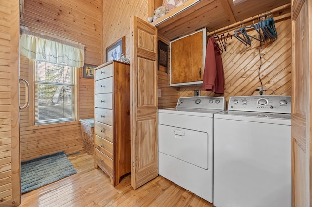32331 Loon Dr, Candor Twp, MN 56587 - laundry area with wood walls, cabinet space, washer and dryer, and light wood-style flooring