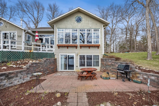 32331 Loon Dr, Candor Twp, MN 56587 - rear view of house featuring a deck, a patio, and a lawn