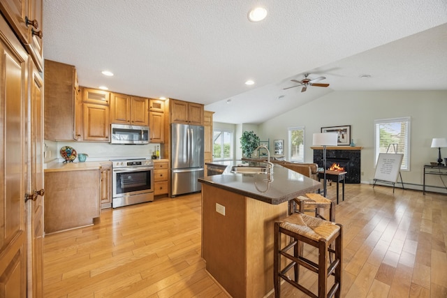 5427 Twin Lake Blvd E, Brooklyn Center, MN 55429 - kitchen with appliances with stainless steel finishes, a sink, a breakfast bar area, ceiling fan, and light wood finished floors