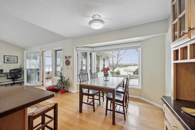 5427 Twin Lake Blvd E, Brooklyn Center, MN 55429 - dining space featuring light wood-type flooring, a desk, a textured ceiling, baseboards, and lofted ceiling