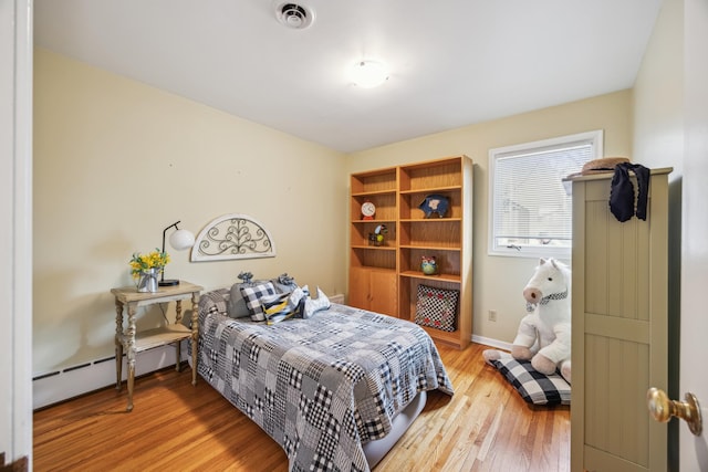 5427 Twin Lake Blvd E, Brooklyn Center, MN 55429 - bedroom with wood finished floors, baseboards, and a baseboard radiator