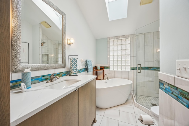 5427 Twin Lake Blvd E, Brooklyn Center, MN 55429 - bathroom featuring a skylight, tile walls, lofted ceiling, a shower stall, and tile patterned flooring