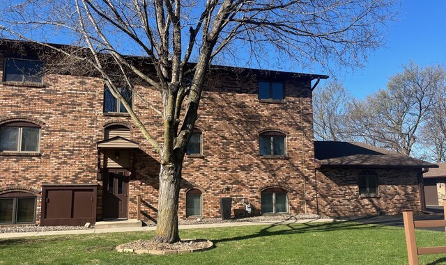 exterior space featuring brick siding and a yard