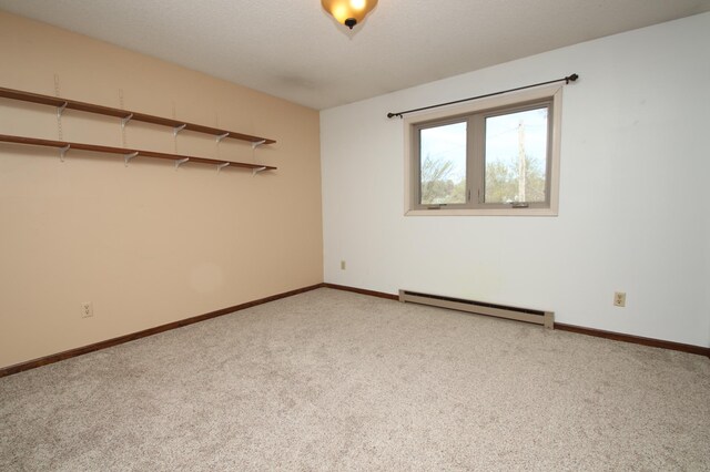 carpeted spare room with baseboards and a baseboard radiator