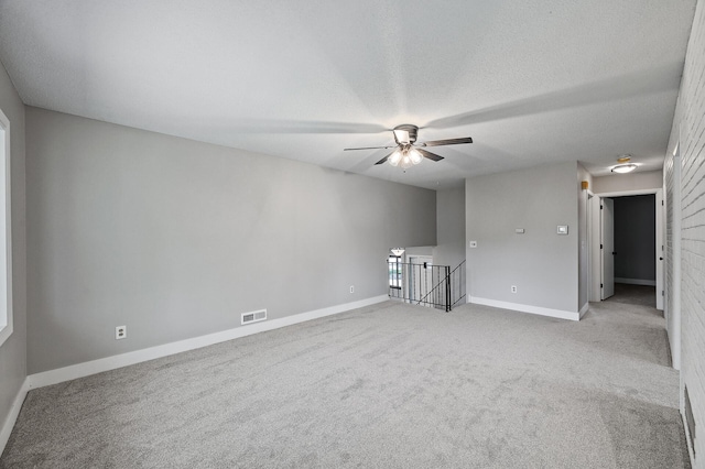 unfurnished room featuring carpet flooring, baseboards, a ceiling fan, and a textured ceiling