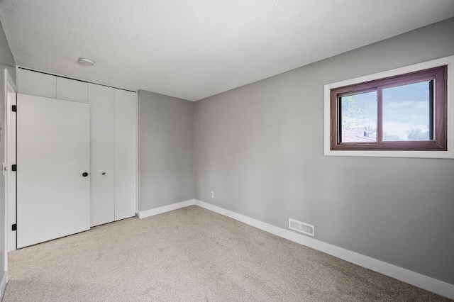 unfurnished bedroom featuring carpet, baseboards, and a closet