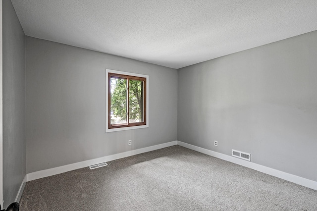 carpeted empty room featuring baseboards and a textured ceiling