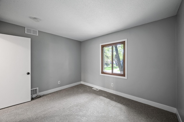 carpeted spare room featuring a textured ceiling, baseboards, and a smoke detector