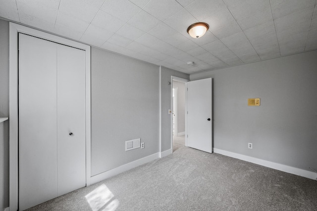unfurnished bedroom with carpet floors, baseboards, and a closet