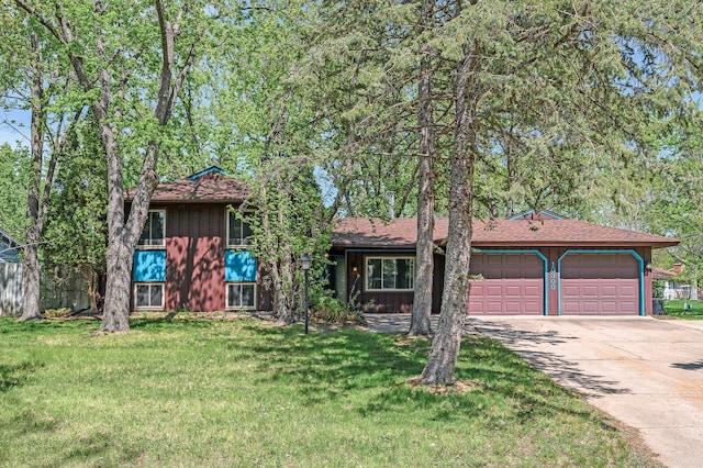 view of front of house with an attached garage, concrete driveway, a front lawn, and board and batten siding