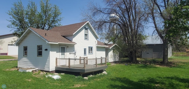 721 Front St, Hawley, MN 56549 - back of house with roof with shingles, a wooden deck, and a lawn