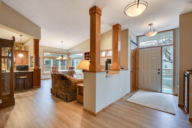 7232 Kestrel Trl, Savage, MN 55378 - entrance foyer with light wood-style floors, ornate columns, vaulted ceiling, baseboards, and a chandelier