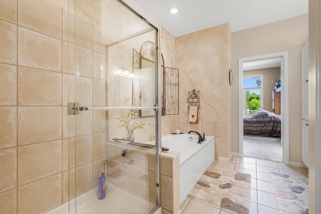 7232 Kestrel Trl, Savage, MN 55378 - ensuite bathroom featuring a bath, a stall shower, tile patterned floors, and baseboards