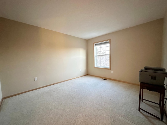carpeted empty room featuring baseboards