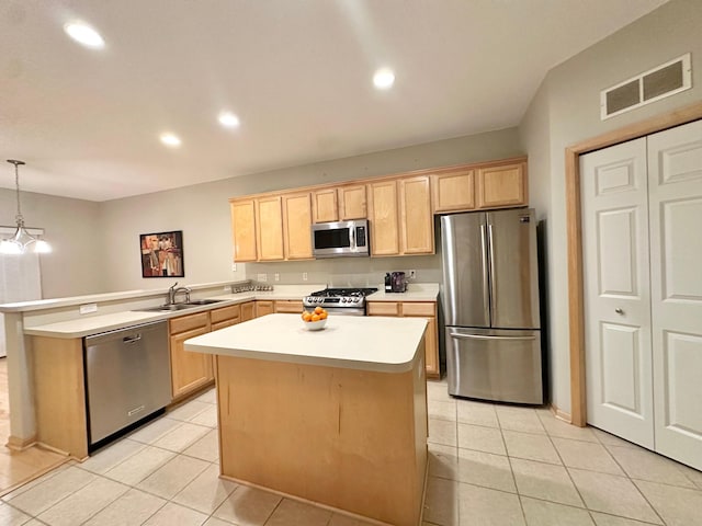 kitchen with stainless steel appliances, a sink, light brown cabinets, a peninsula, and light countertops