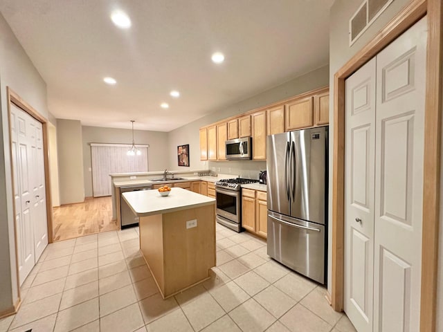 kitchen with stainless steel appliances, a peninsula, recessed lighting, light countertops, and a sink