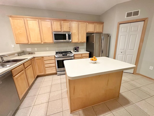 kitchen with stainless steel appliances, light brown cabinets, light tile patterned flooring, and a sink