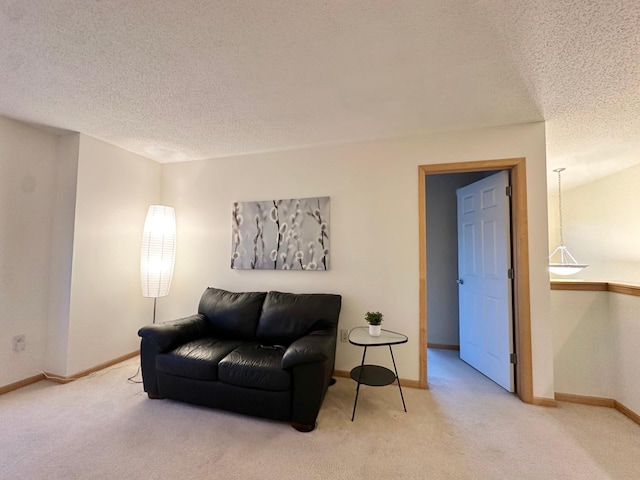 carpeted living area with a textured ceiling and baseboards