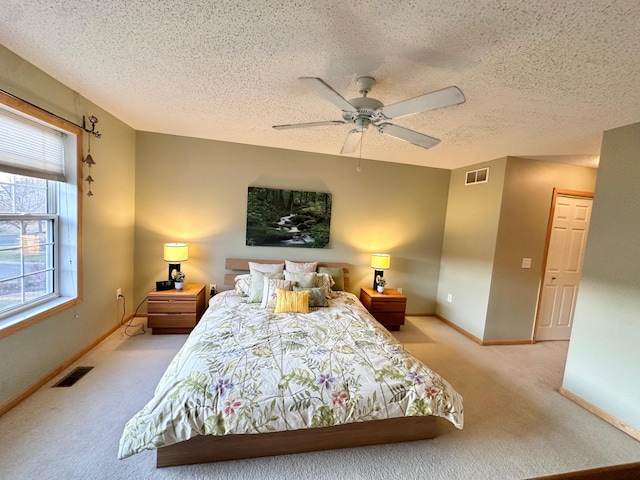 bedroom featuring carpet floors, baseboards, a textured ceiling, and ceiling fan