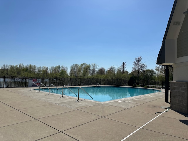 community pool with fence and a patio area