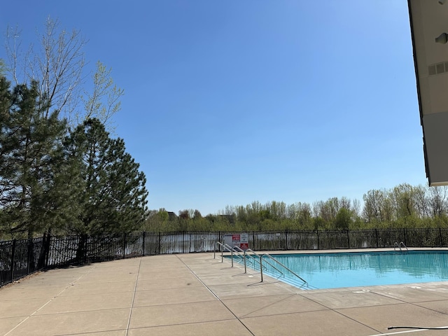 community pool with fence and a patio area