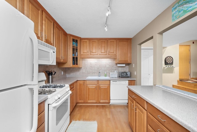 4860 Park Commons Dr Unit 314, Saint Louis Park, MN 55416 - kitchen featuring white appliances, light wood-style flooring, backsplash, light countertops, and glass insert cabinets