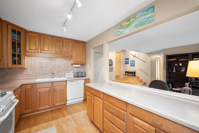 4860 Park Commons Dr Unit 314, Saint Louis Park, MN 55416 - kitchen with white appliances, light wood-style flooring, glass insert cabinets, light countertops, and tasteful backsplash