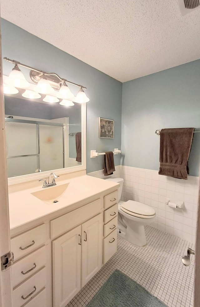 4860 Park Commons Dr Unit 314, Saint Louis Park, MN 55416 - full bathroom with vanity, a shower stall, a textured ceiling, tile patterned flooring, and wainscoting