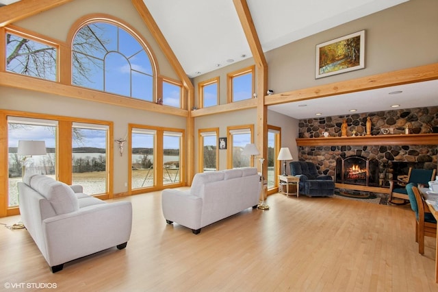 2300 County Road 92, Minnetrista, MN 55359 - living room featuring wood finished floors, healthy amount of natural light, a fireplace, high vaulted ceiling, and a water view