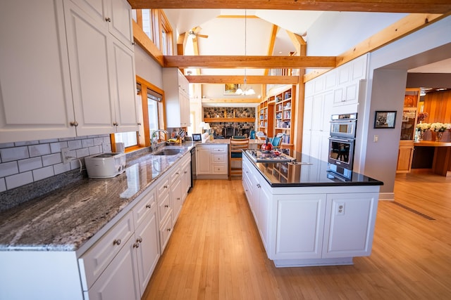 2300 County Road 92, Minnetrista, MN 55359 - kitchen with stainless steel appliances, white cabinetry, a kitchen island, light wood-style flooring, and tasteful backsplash