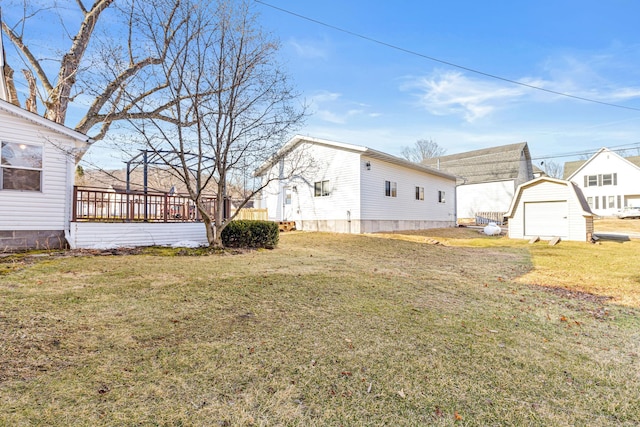 view of yard featuring a garage, a shed, and an outbuilding