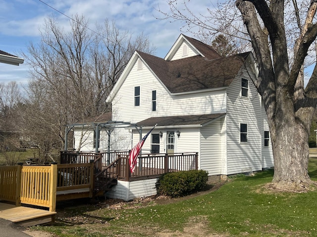 rear view of house with roof with shingles, a deck, a pergola, and a yard
