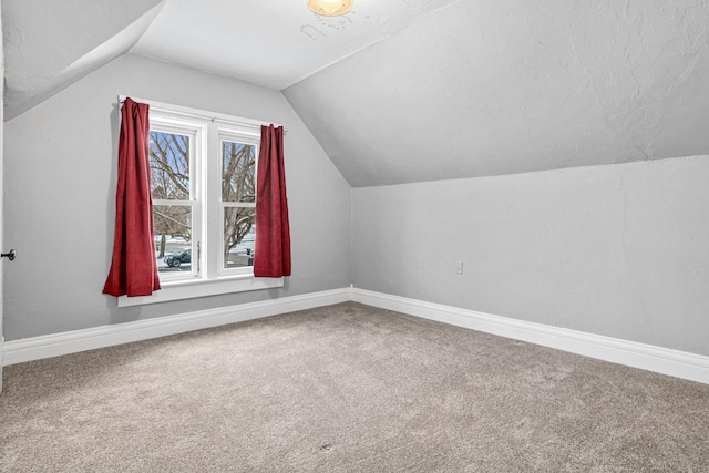 additional living space with carpet, vaulted ceiling, and baseboards