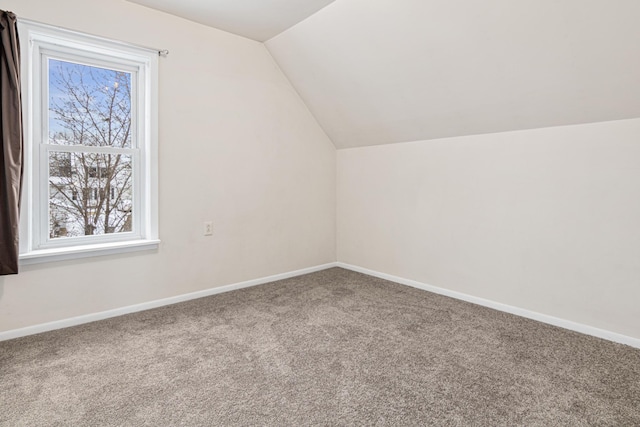 additional living space with baseboards, a wealth of natural light, carpet flooring, and vaulted ceiling
