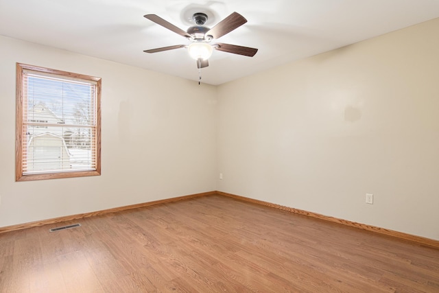 empty room featuring visible vents, baseboards, a ceiling fan, and light wood-style floors