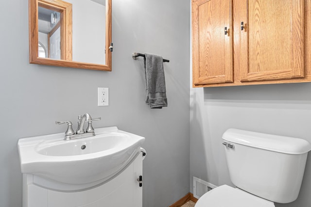 bathroom featuring visible vents, toilet, and vanity